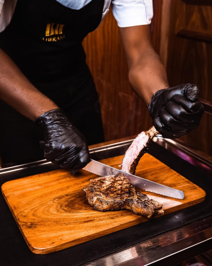 A chef at Cee 4 Arena slicing through a steak
